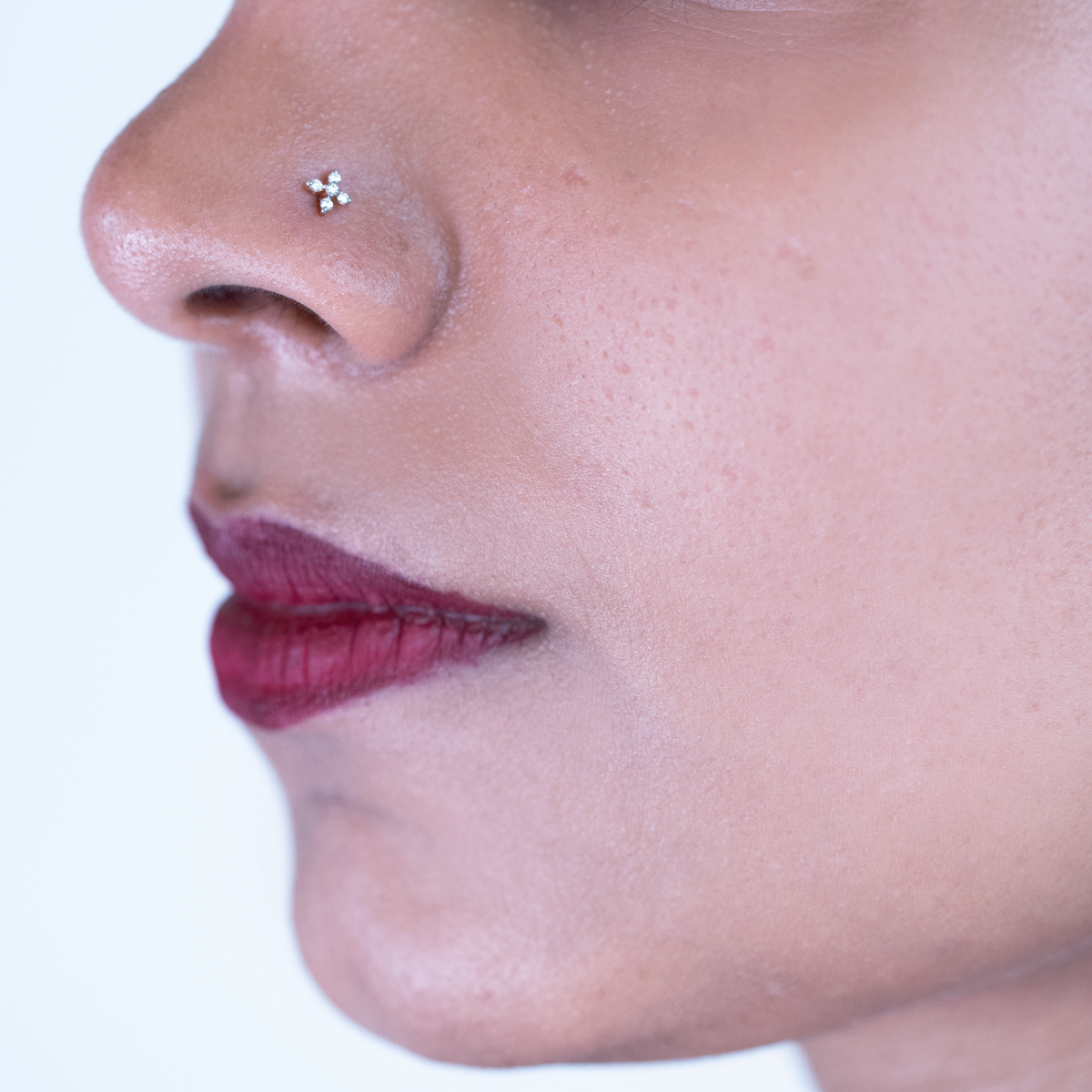 model wearing minimal five stone diamond nose pin