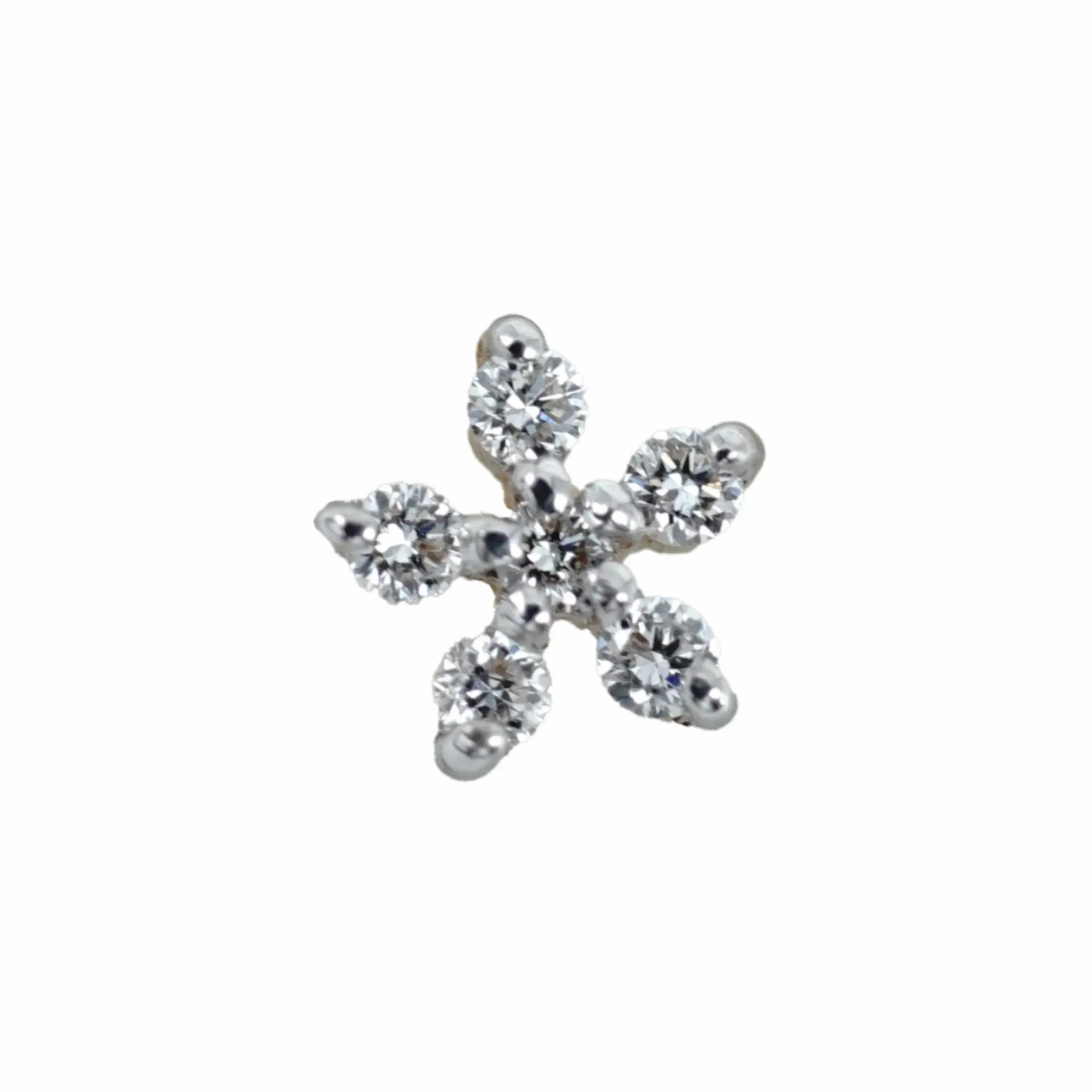 Six-stone diamond nose pin in 18k gold with round brilliant-cut diamonds in a flower design, shown in close-up detail.