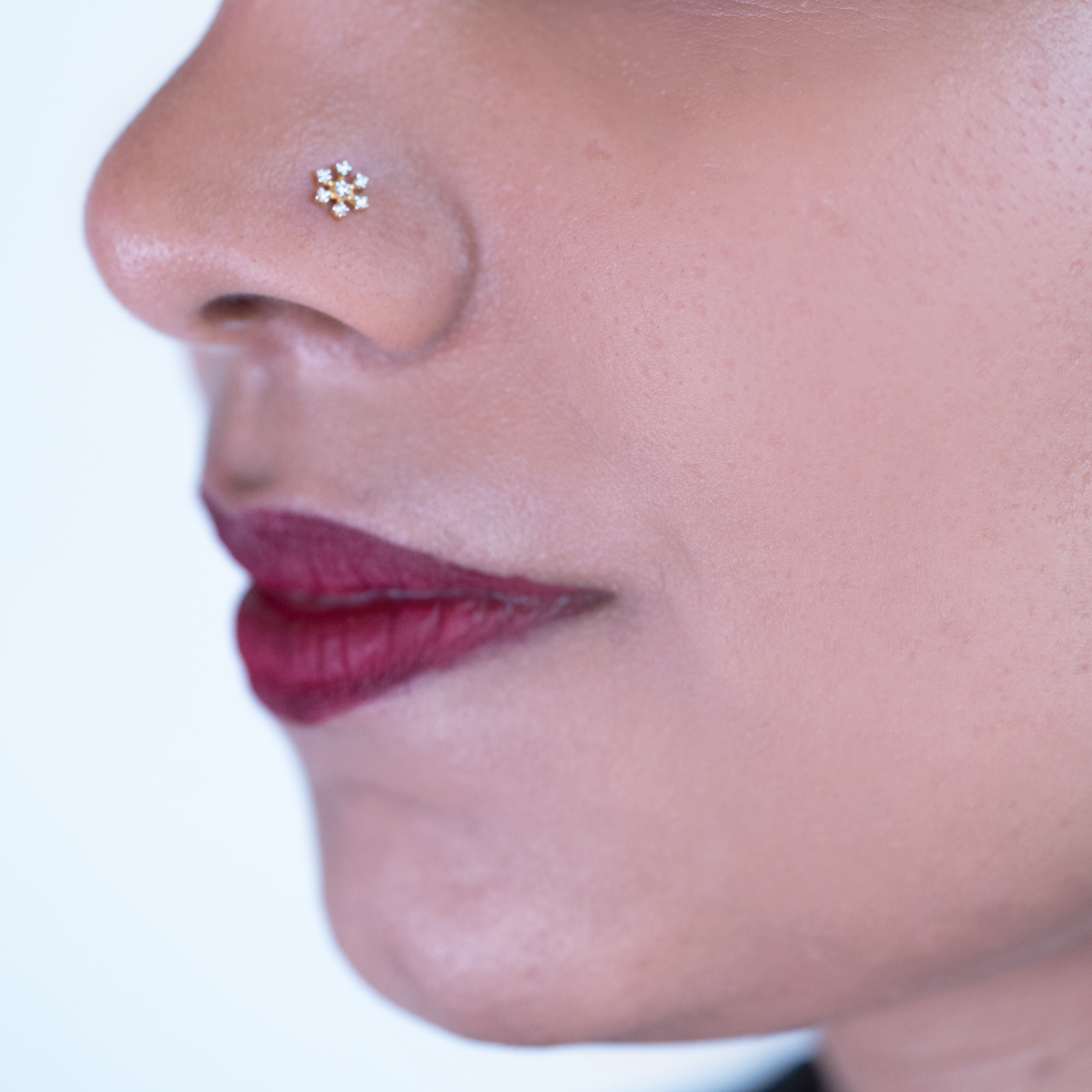 model wearing best diamond floral nose pin of Damaru Gold and diamonds.