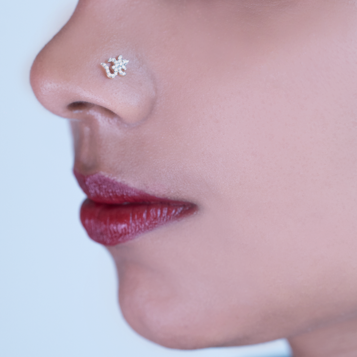 model wearing traditional ohm shaped diamond nose pin.