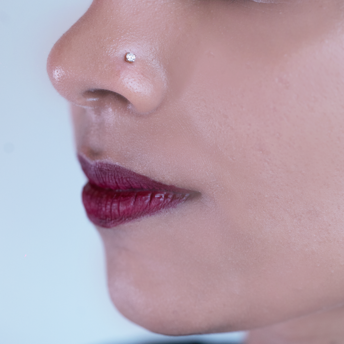model wearing simple single stone diamond nose pin
