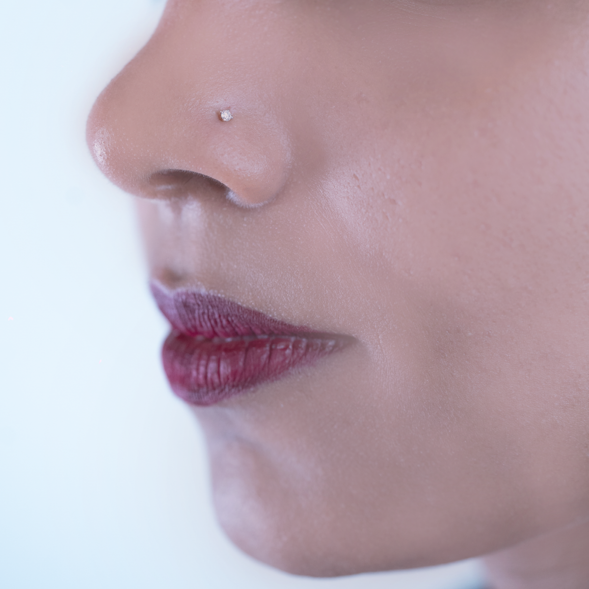 model wearing minimalist single nose pin. 